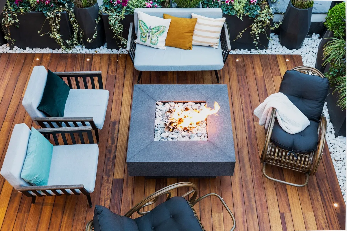 A modern patio with stylish furniture and a central firepit, ideal for enjoying outdoor spaces.